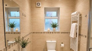 Ein modernes Badezimmer mit Waschbecken, Toilette und Duschbereich.