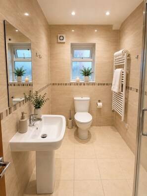 Ein modernes Badezimmer mit Waschbecken, Toilette und Duschbereich.