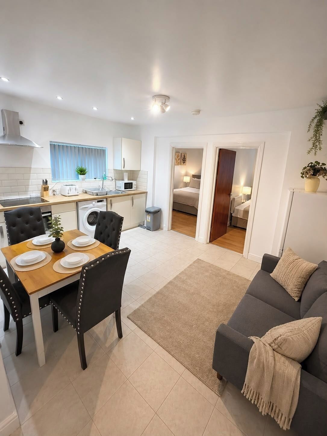 A modern apartment with a dining area, kitchen, and living room.
