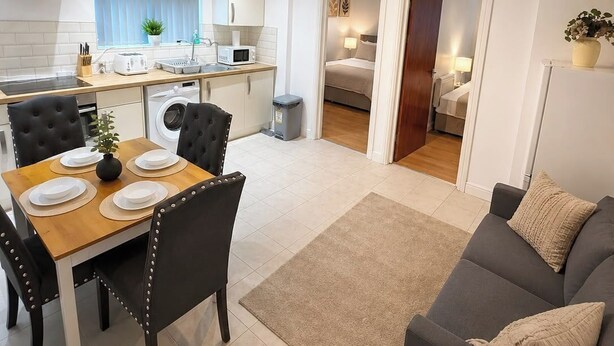 Ein modernes Apartment mit Essbereich, Küche und Wohnzimmer.