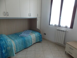 A bedroom with a single bed, a radiator, and a window. - Residence La Cicala Palmi (Palmi)