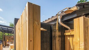 A wooden outdoor shower enclosure with a hose and showerhead. - 4 Star Holiday Home in Ebeltoft (Ebeltoft)