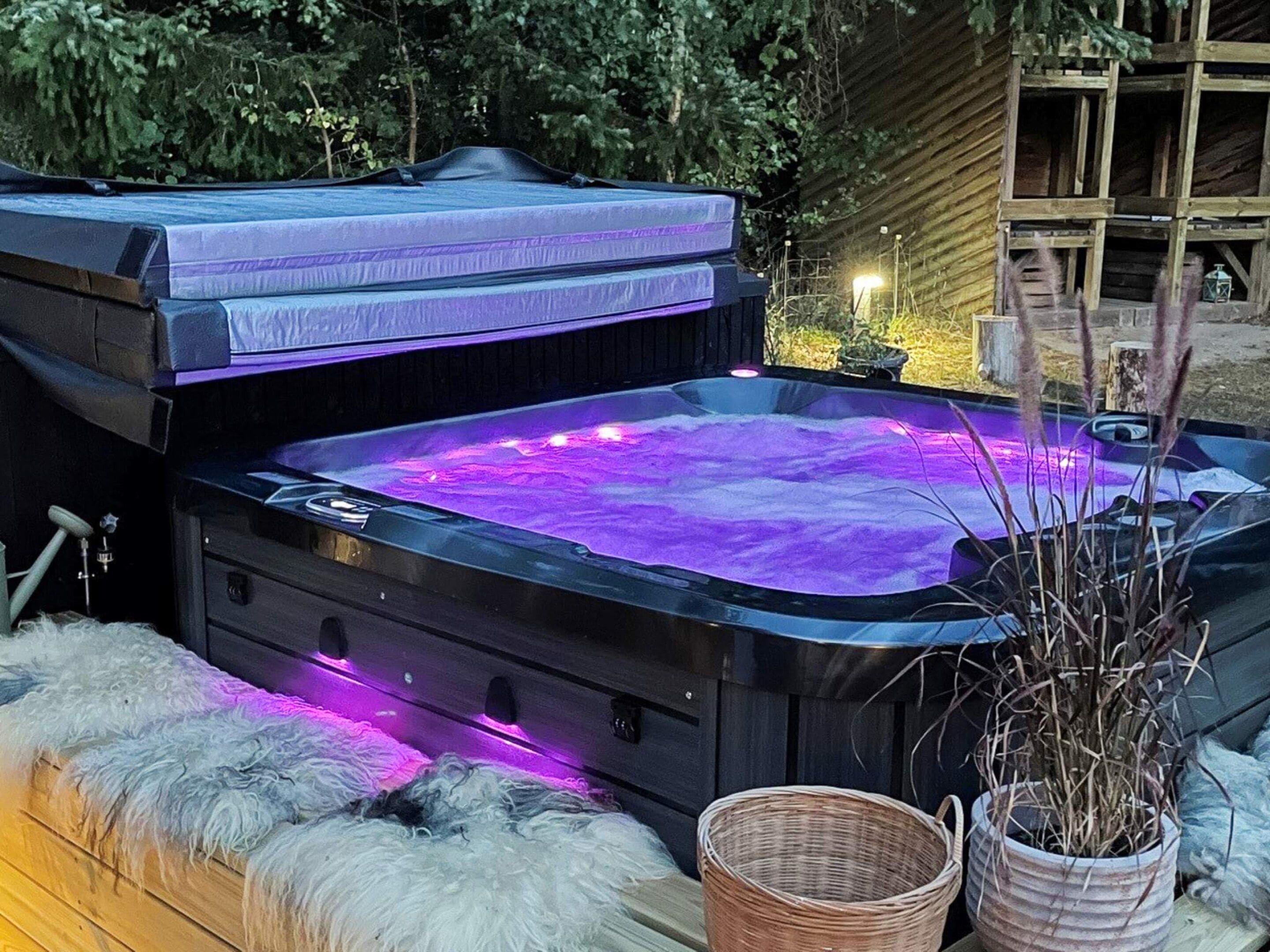 Un bain à remous avec une terrasse en bois et une plante en pot.