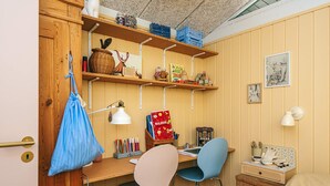 A cozy room with a wooden desk, two chairs, a bed, and shelves with various items. - 4 Star Holiday Home in Ebeltoft (Ebeltoft)