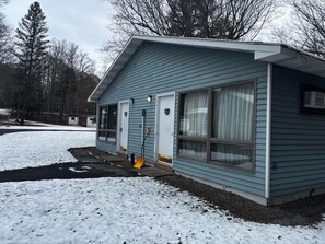 A small, single-story building with a gabled roof, a front door, and large windows. - Cozy 1-bedroom hotel room, Hamilton - 314 Gilbreth (Hamilton)