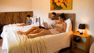 Una habitación de hotel con cama, mesita de noche, lámpara y un cuadro en la pared.