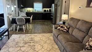 A living room with a sofa and a dining area with a table and chairs.