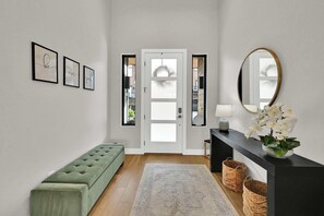 A hallway with a green bench, a mirror, framed artwork, and a door with frosted glass panels. - 3BR Park City View Home | Hot Tub | Pet-Friendly (Hideout)