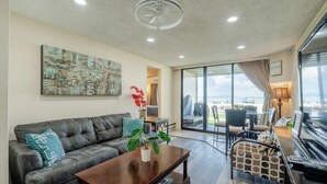 Una sala de estar moderna con un sofá de cuero, una mesa de centro de madera y un ventanal con vistas.