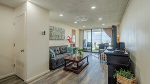 Una sala de estar moderna con sofá, mesa de centro y mueble para televisión.