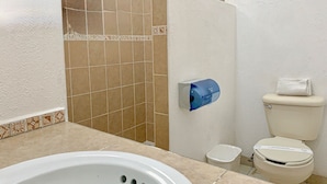 A bathroom with a bathtub, toilet, and shower area. - Hotel y Condominios Jaroje (Crucecita)