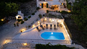 En villa med en swimmingpool, en uteplats och en gångstig av sten.