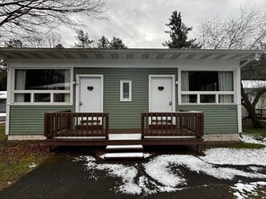A small, two-room cabin with a front porch and steps leading to the entrance.