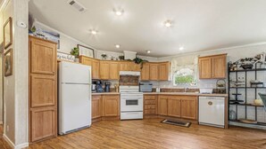 Una cocina con armarios de madera, un refrigerador, una estufa y un lavavajillas.