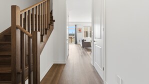 A wooden staircase leading to a living area with a view of the outdoors.