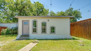 A small, single-story house with a front door, two windows, and a small porch. - Spacious Dallas Home + Guest House | Sleeps 21 (Dallas)