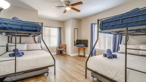 A room with bunk beds, a ceiling fan, a TV, and a chair. - Spacious Dallas Home + Guest House | Sleeps 21 (Dallas)