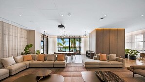 Een ruime woonkamer met een grote hoekbank, een eettafel en uitzicht op de omgeving.