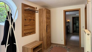 A hallway with wooden wardrobes, a bench, and a radiator.