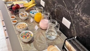 A breakfast buffet with various food items, a coffee machine, and a toaster.
