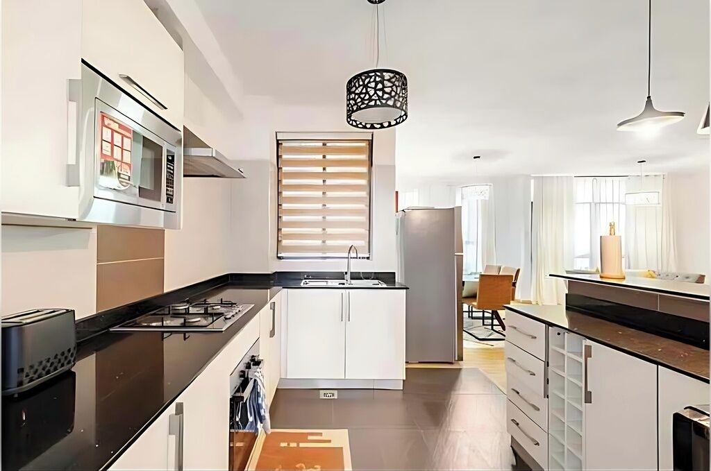 Una cocina moderna con microondas, estufa y pileta.