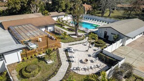 An aerial view of a residential property with a swimming pool, patio seating, and a small garden area. - 12 BR Estate!•HeatedPool • Pickle • GameRm •Events (Clearwater)