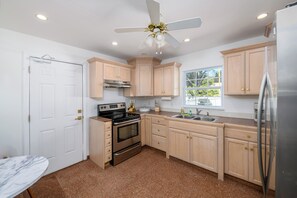 A kitchen with light wooden cabinets, a stainless steel refrigerator, a built-in oven, and a ceiling fan. - 12 BR Estate!•HeatedPool • Pickle • GameRm •Events (Clearwater)