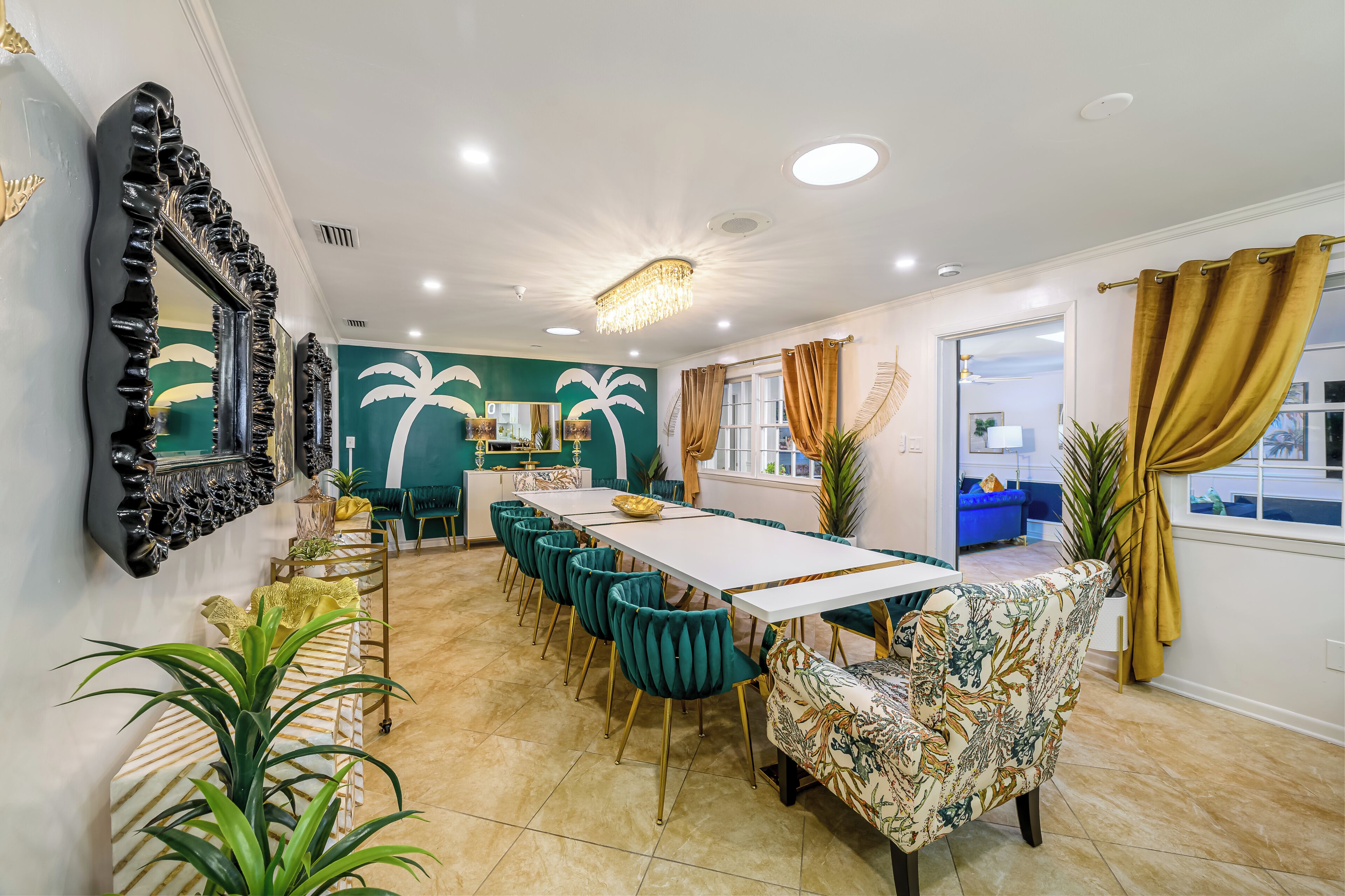 A dining area with a long table, teal chairs, and a patterned bench.
