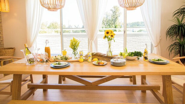 A dining table set with various dishes, drinks, and a vase of sunflowers. - Resort House Daisho G Uruma (Uruma)
