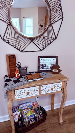 A wooden console table with decorative drawers, a mirror, and a framed welcome sign. - River Pointe Getaway - Pigeon Forge Home + River Access, 3 Mins to the Parkway (Pigeon Forge)