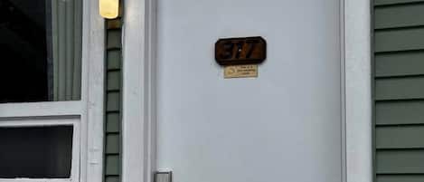 A white door with a brass plaque reading '317' and a non-smoking sign.