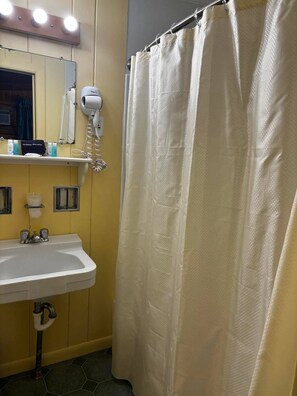 Baño con lavabo, espejo y cortina de ducha.