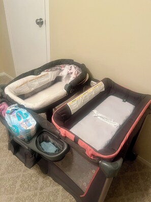 A traveler's suitcase with a baby stroller attached, a diaper bag, and a travel blanket.