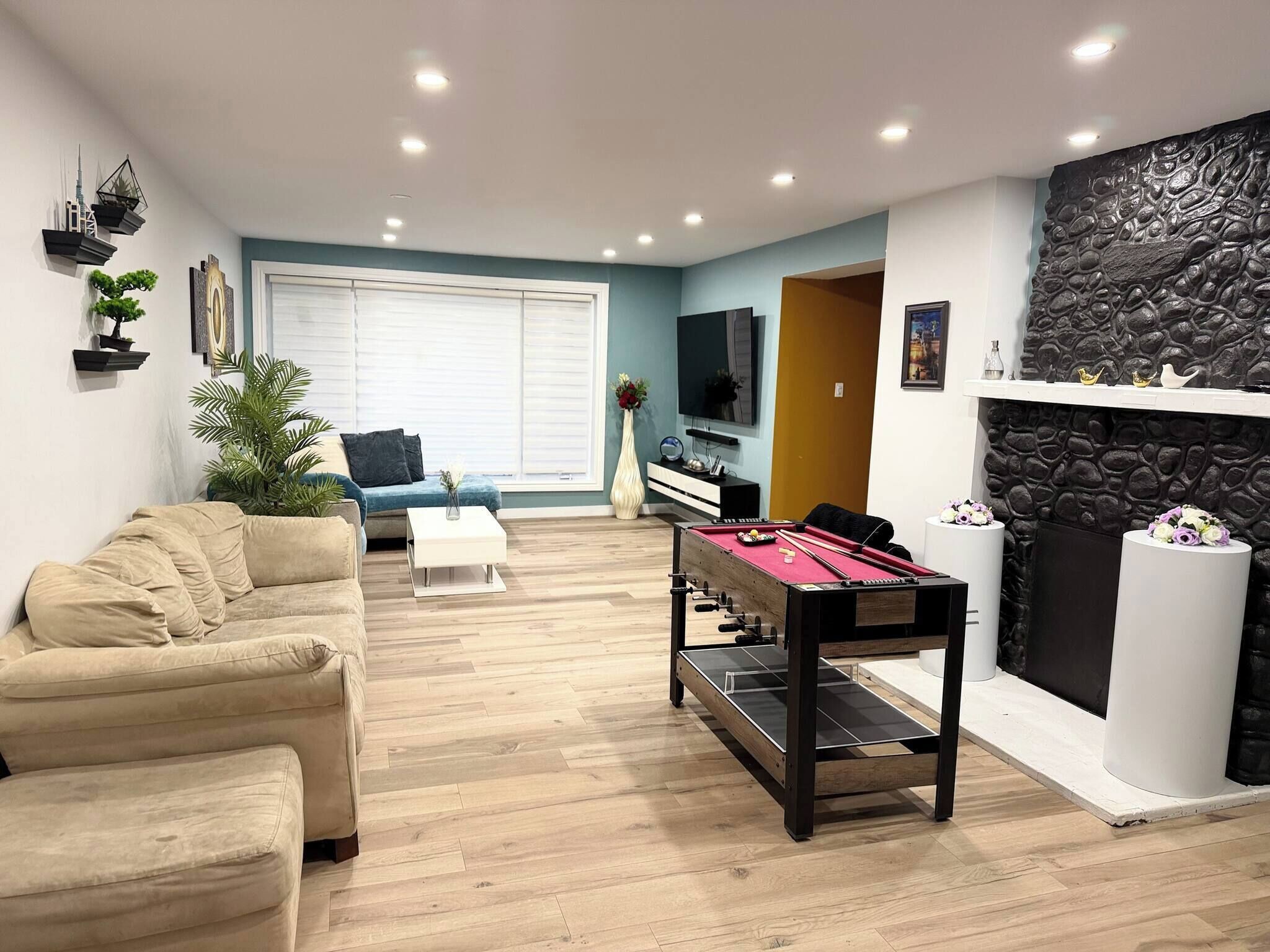 Un salon comprenant un canapé, une table basse, une table de billard et une cheminée.