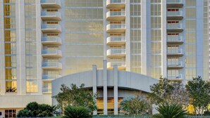 A high-rise hotel with multiple balconies, a curved entrance, and a modern architectural design. - MGM Signature-04-609 Strip View Jacuzzi Studio (Las Vegas)