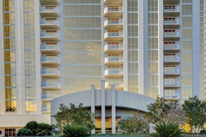 A high-rise hotel with multiple balconies, a curved entrance, and a modern architectural design. - MGM Signature-04-609 Strip View Jacuzzi Studio (Las Vegas)