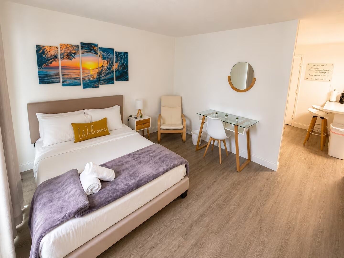 Une chambre d’hôtel équipée d’un lit, d’un bureau, d’une chaise et d’un miroir fixé au mur.