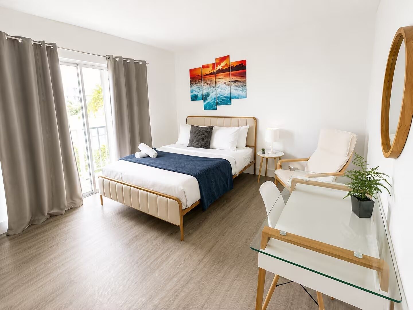 Une chambre d’hôtel avec un lit, une chaise, un bureau, une lampe et un tableau au mur.