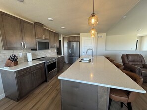 A modern kitchen with a central island, stainless steel appliances, and wooden cabinetry.