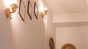 Eine Treppe mit einem Holzkabinett am Fuß, einer Wand mit gerahmten Bildern und zwei Wandleuchten.