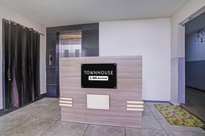 A reception desk with a sign that reads 'TOWNHOUSE' and 'OYO-Serviced'.