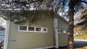 Un bâtiment d’un seul étage, à la façade verte, avec une plaque indiquant le nom « ISHENANDROAD », et un arbre devant.