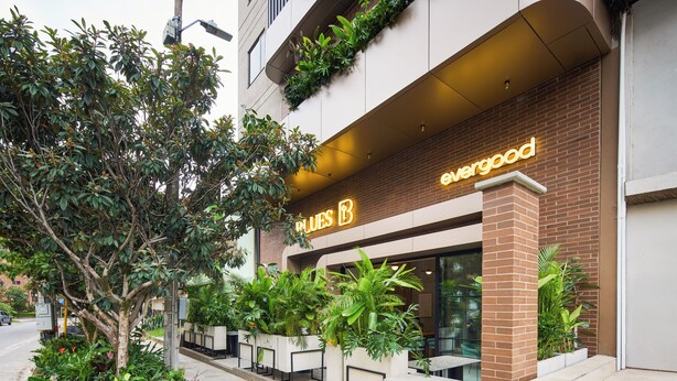 Un bâtiment avec une enseigne sur laquelle on peut lire « evergood » et une rangée de sièges installés à l’extérieur.