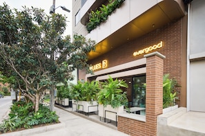 A building with a sign that reads 'evergood' and a row of outdoor seating. - Blues Suites Laureles (Medellin)