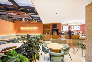 A modern cafe interior with seating arrangements, a counter, and a menu display.