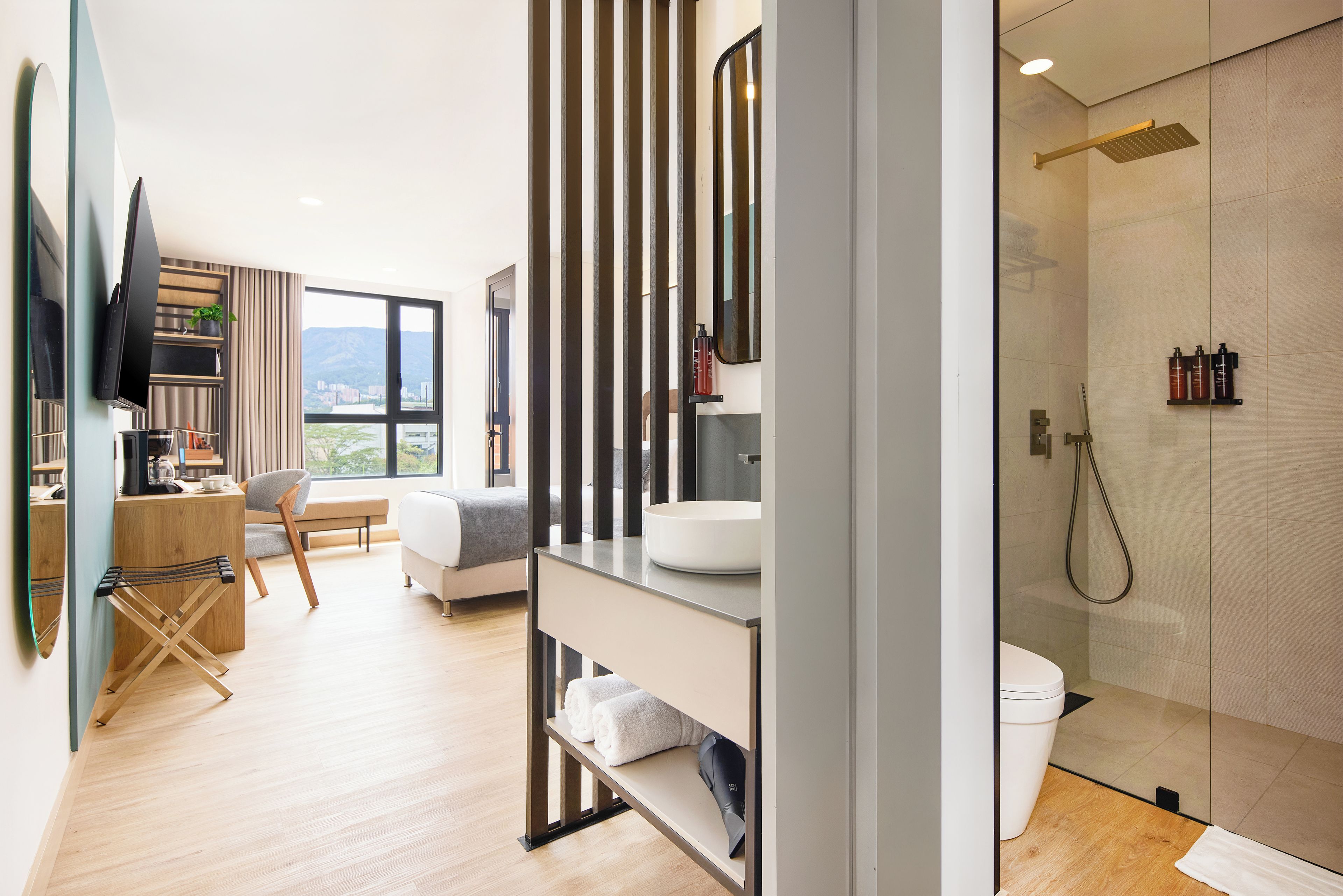 A modern bathroom with a glass-enclosed shower, a white sink, and a toilet.