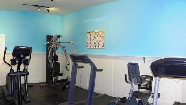 A gym with cardio machines and a wall calendar. - Welcome to Heidi's Nest! Renovated 2BR Condo in Bradenton Beach/Runaway Bay! (Bradenton Beach)