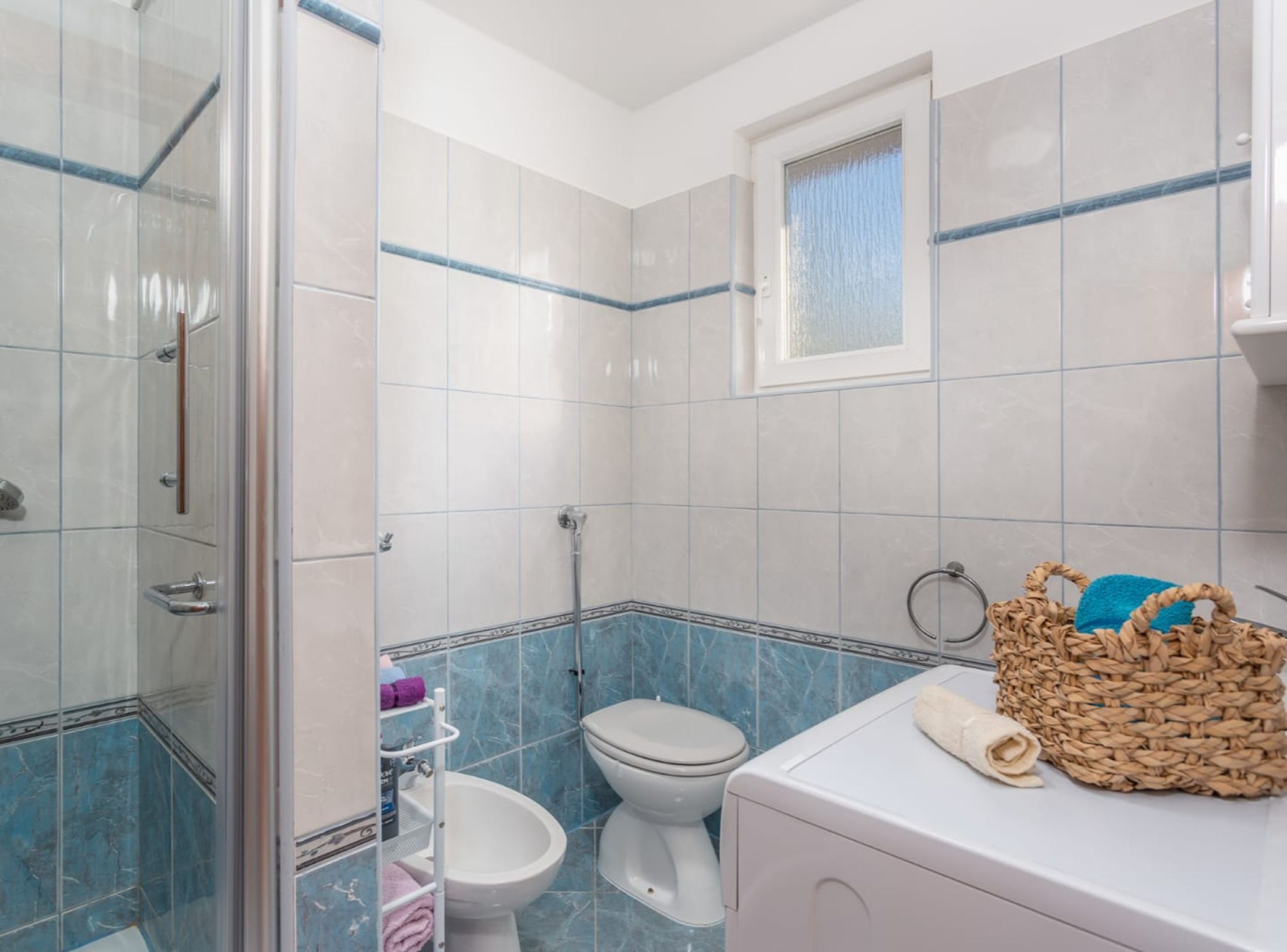 A bathroom with a shower, toilet, and sink.