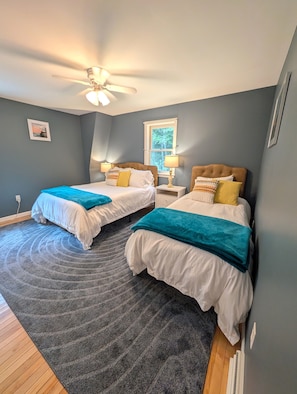 A bedroom with two beds, a ceiling fan, a window, and a rug. - Lakeside Haven on Whites Pond (Palmyra)