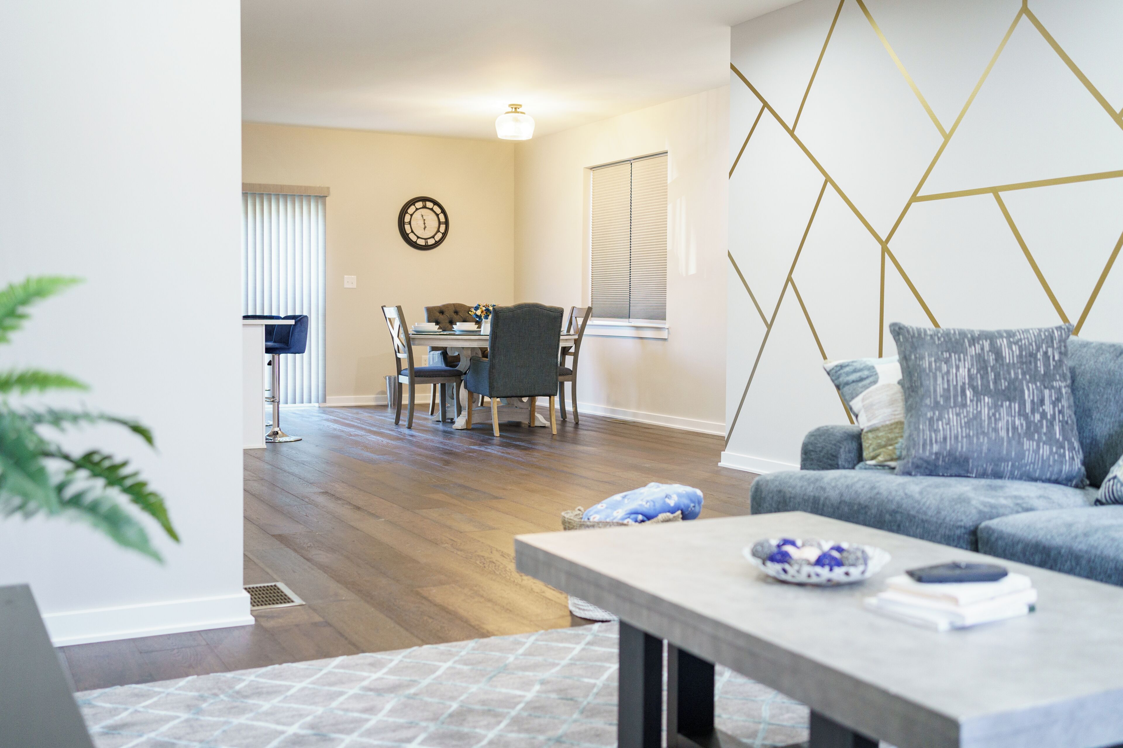 A modern living room with a dining area, a sofa, and a coffee table.